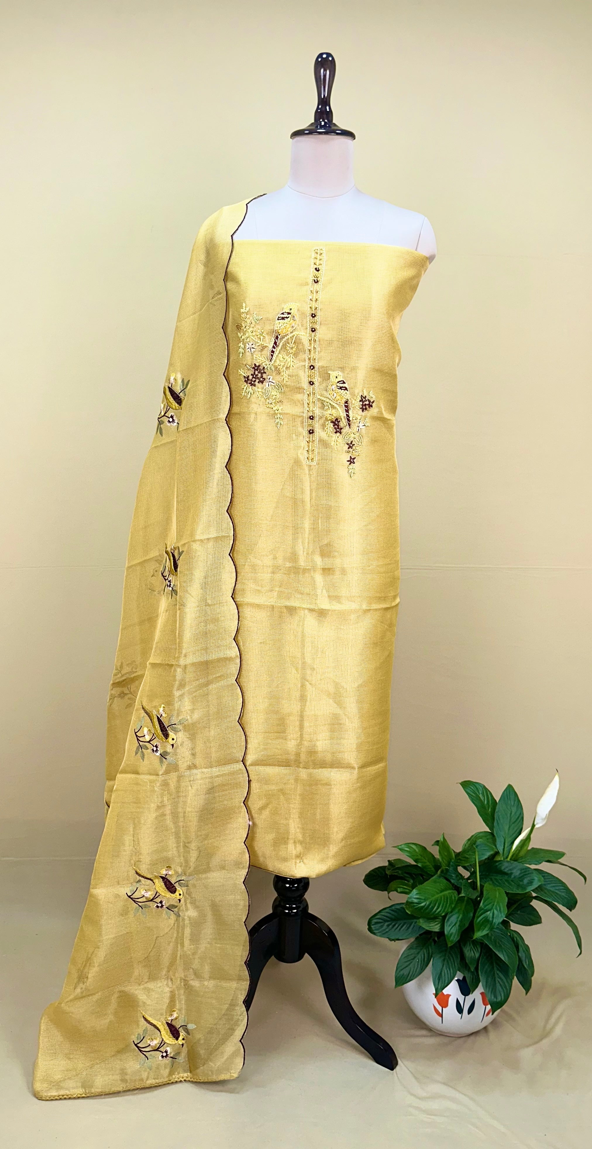 Yellow Kora Adorned with Intricate Embroidered Motifs Including a Bird and Floral Patterns, Commonly Crafted Using Techniques Like Zardosi and Kantha Work Unstitched Suit